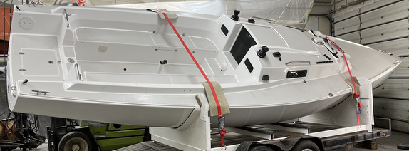 White boat secured on a trailer indoors.