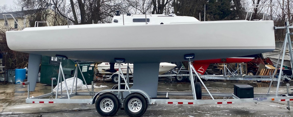 Sailboat on trailer in outdoor setting.