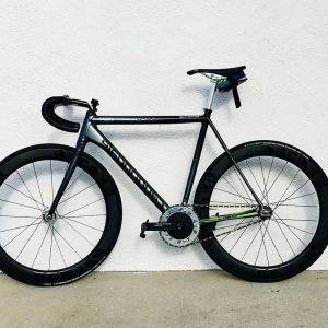 Sleek black and silver bicycle with deep-section wheels against a white wall.