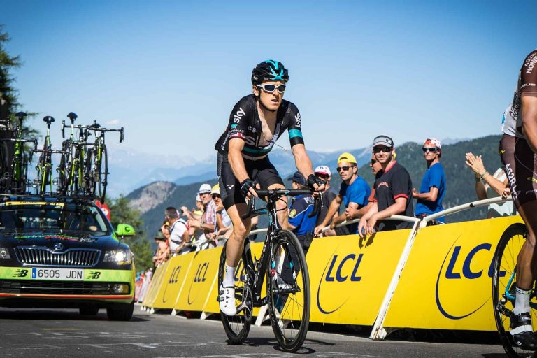 Cyclist racing past cheering crowd during a cycling event.