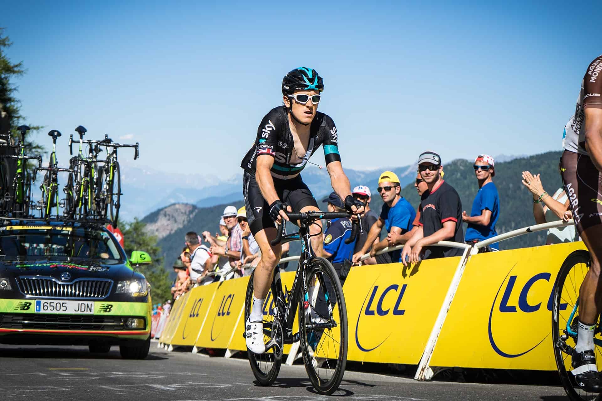 Cyclist racing past cheering crowd during a cycling event.