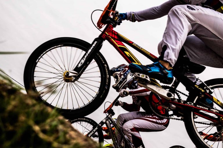 Close-up of a BMX rider performing a jump with a bright bike and gear.