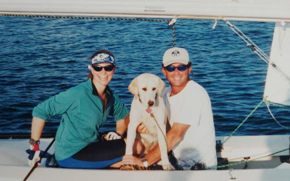 Two people and dog on a boat.