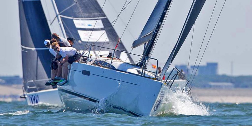 Sailboat racing through choppy waters with crew focused on navigation.