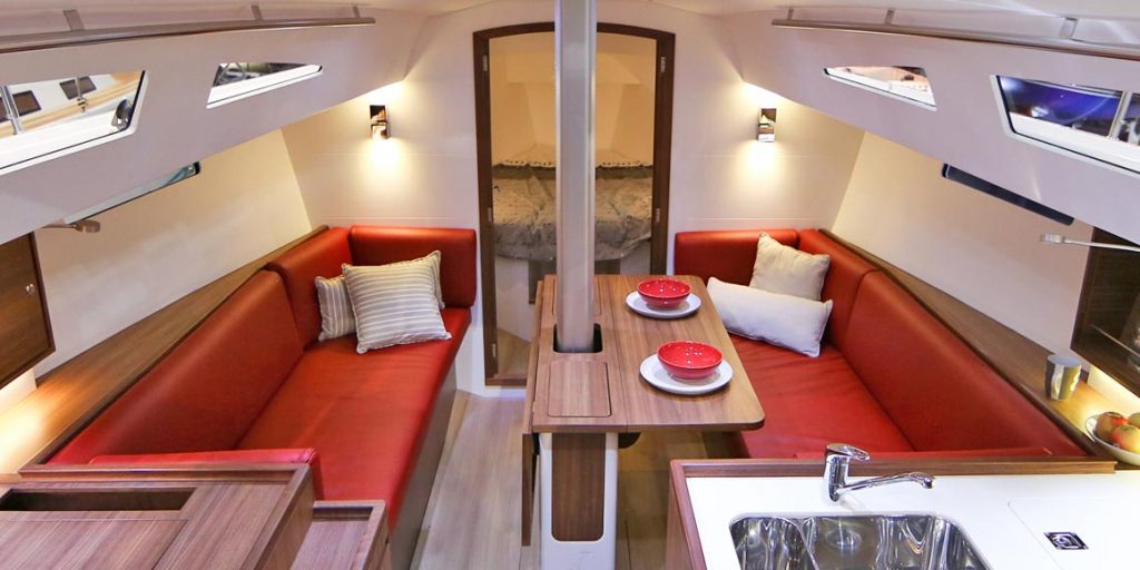 Cozy RV dining and seating area with red sofas and modern lighting.