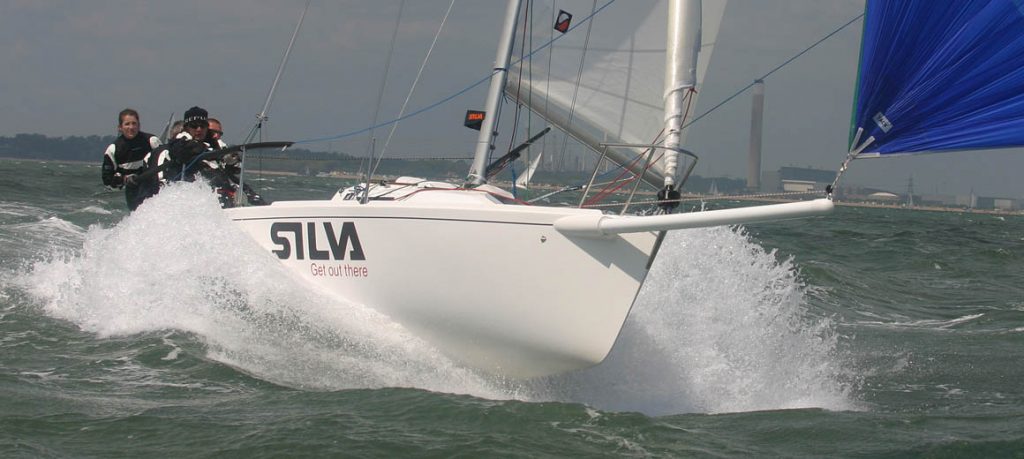 Close-up of a sailboat cutting through water on a windy day.