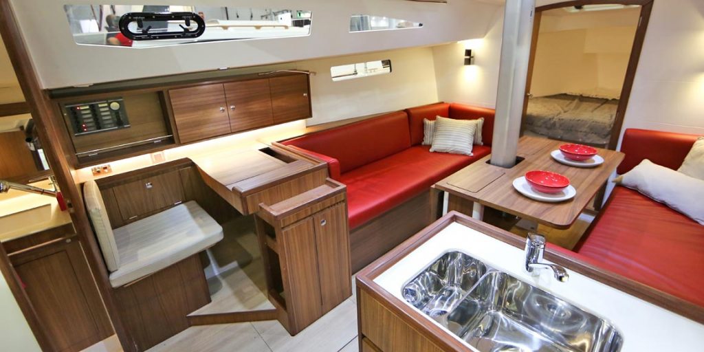 Modern yacht interior with red seating and wooden accents.