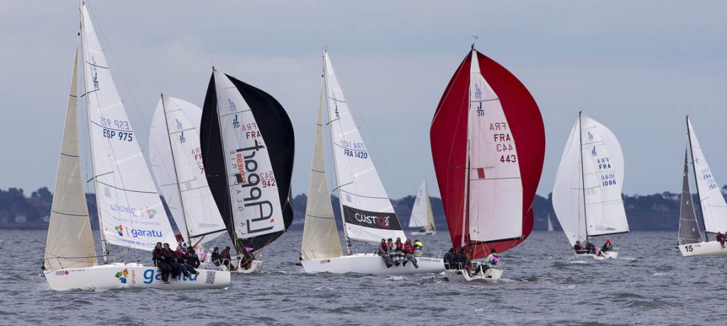 Sailboats racing on a sunny day with colorful sails.