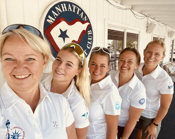 Group of women smiling at yacht club.