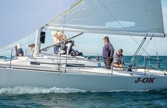 Sailboat with crew on open water.