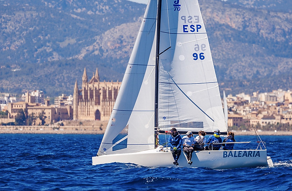 Sailboat in front of coastal historic cathedral.