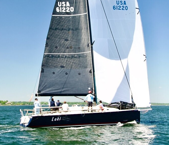 Sailboat with crew on open water.