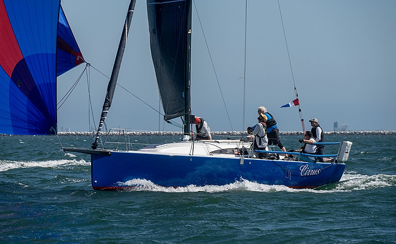 Sailboat with crew navigating on open water.