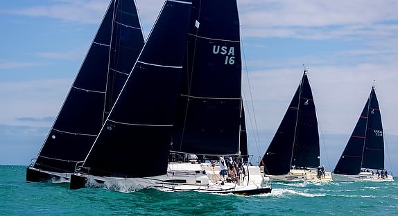 Sailboats racing on the ocean water.