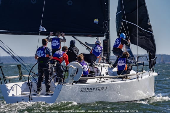 Sailboat racing with crew on deck.