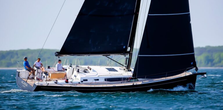 Sailboat with black sails on water.