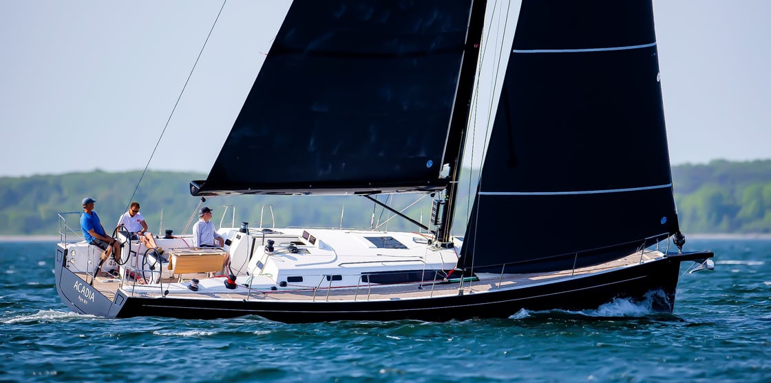 Sailboat with black sails on water.