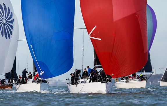 Sailboats racing with colorful spinnakers deployed.