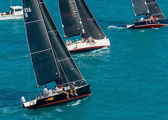 Sailboats racing on turquoise ocean water.