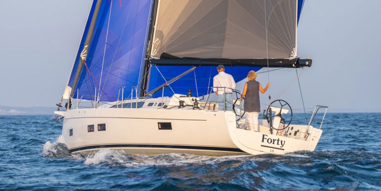 Couple sailing on a boat named Forty during a sunny day.