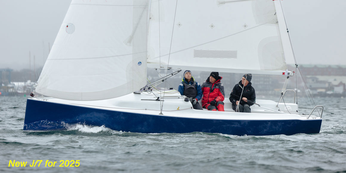 Three people sailing on a small sailboat in calm waters.