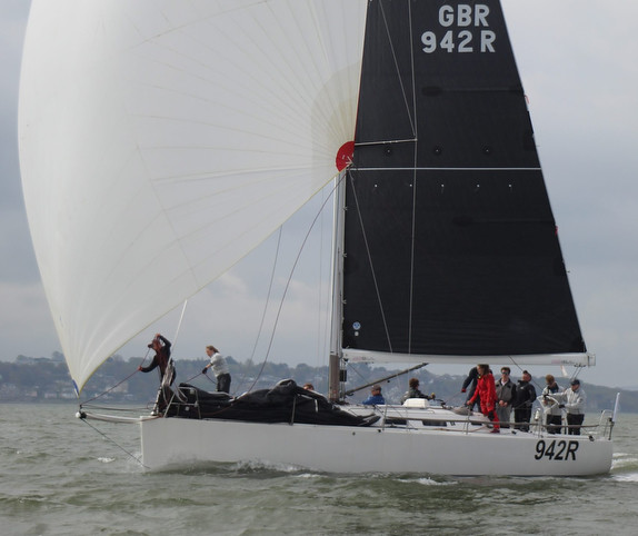 Sailboat with crew on the water.