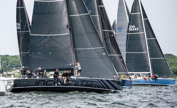 Sailboats racing on choppy water under overcast skies.