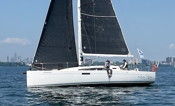 Sailboat on water with city skyline background.