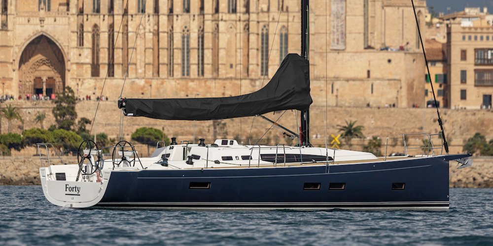 Sailboat on water with historic building background.