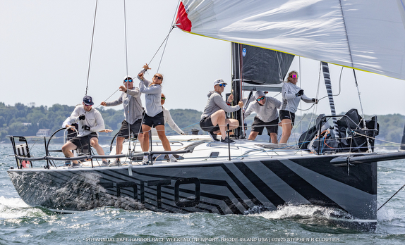 Sailors racing on a yacht in action.