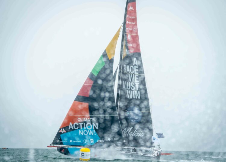 A colorful sailboat with action-themed graphics sails on a misty sea.
