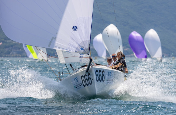 Two sailboats racing closely on choppy waters with vibrant sails.