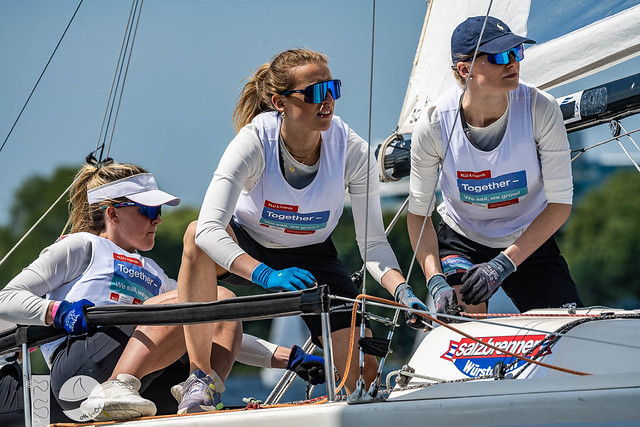 Women sailing team in action on boat.
