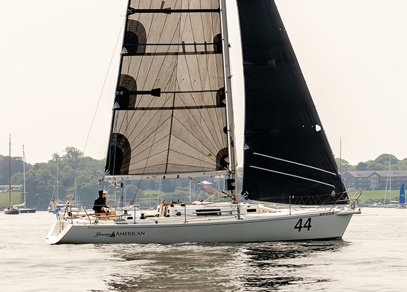 Sailboat with black sails on calm water.