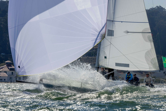 Sailboats racing on choppy sea water.