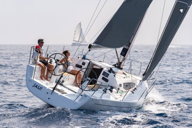 Sailing boat with crew on open water.