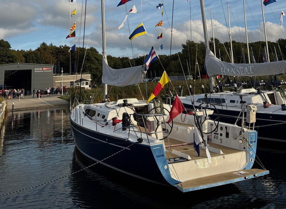 Sailboats docked with colorful flags displayed.