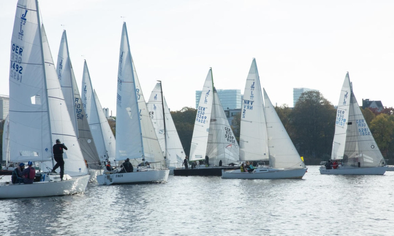 Sailboats racing on a calm lake.