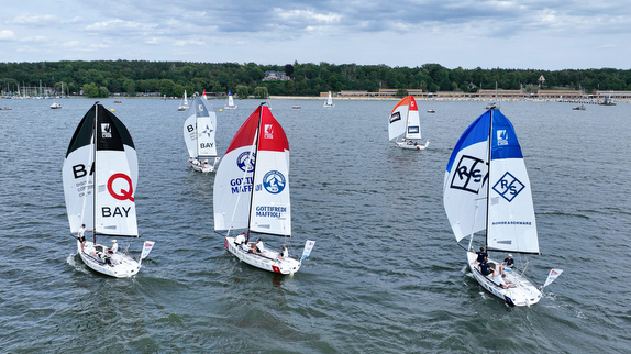 Sailboats racing on a lake under clouds.