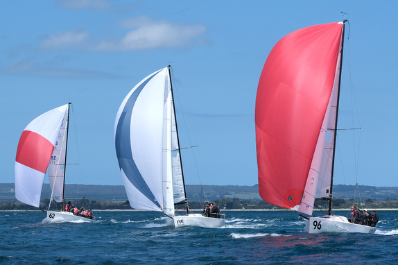 Sailboats racing on open blue water.