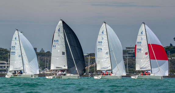 Two sailboats racing on calm waters with contrasting sails.