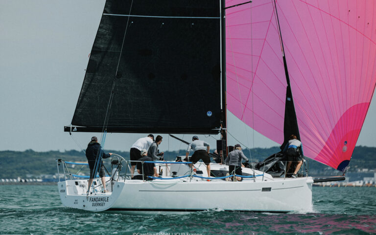 Sailboat with pink spinnaker and crew